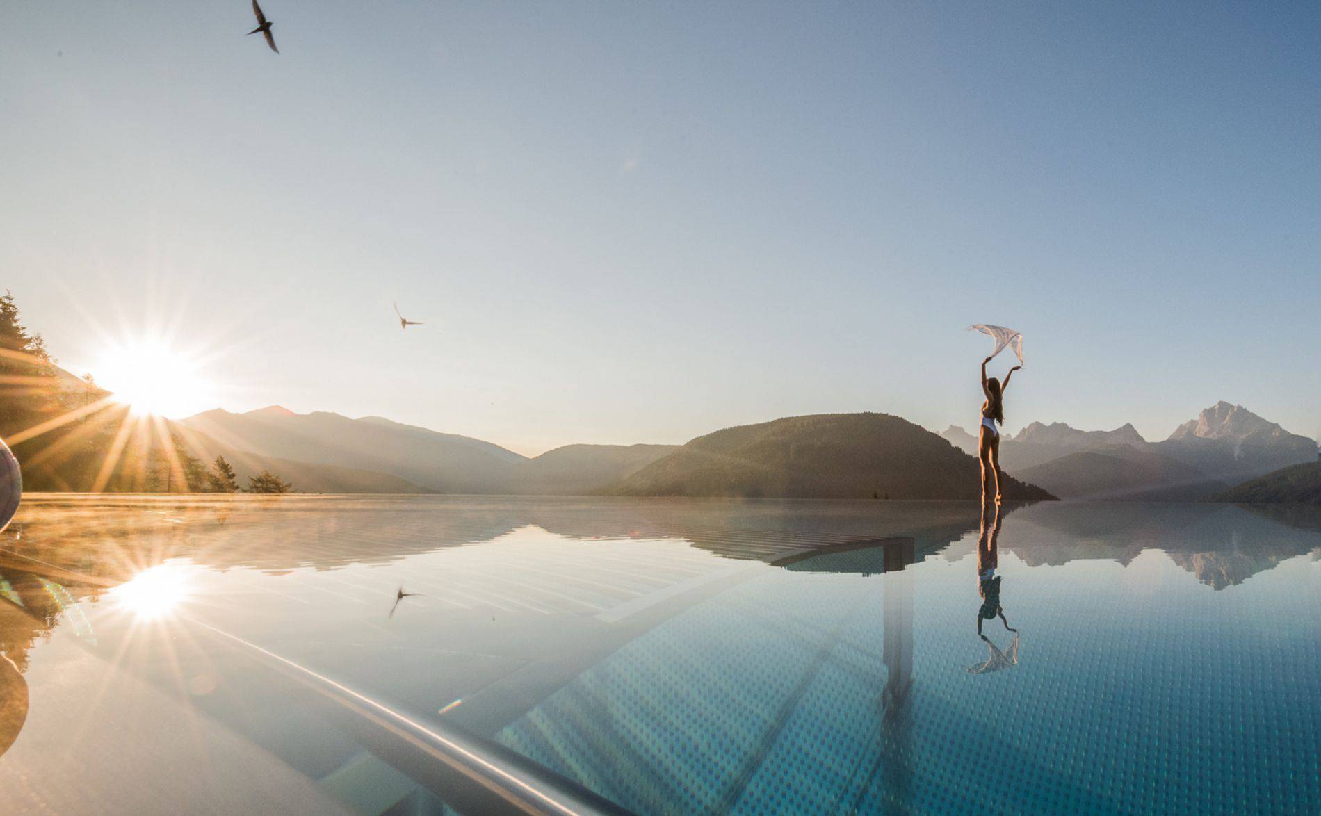 Woman stands at the edge of the pool and enjoys the view
