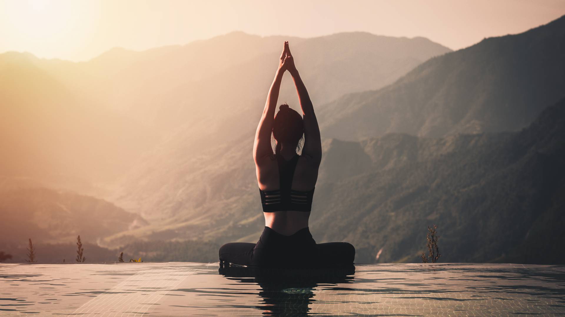 Frau macht Yoga Pose am Pool