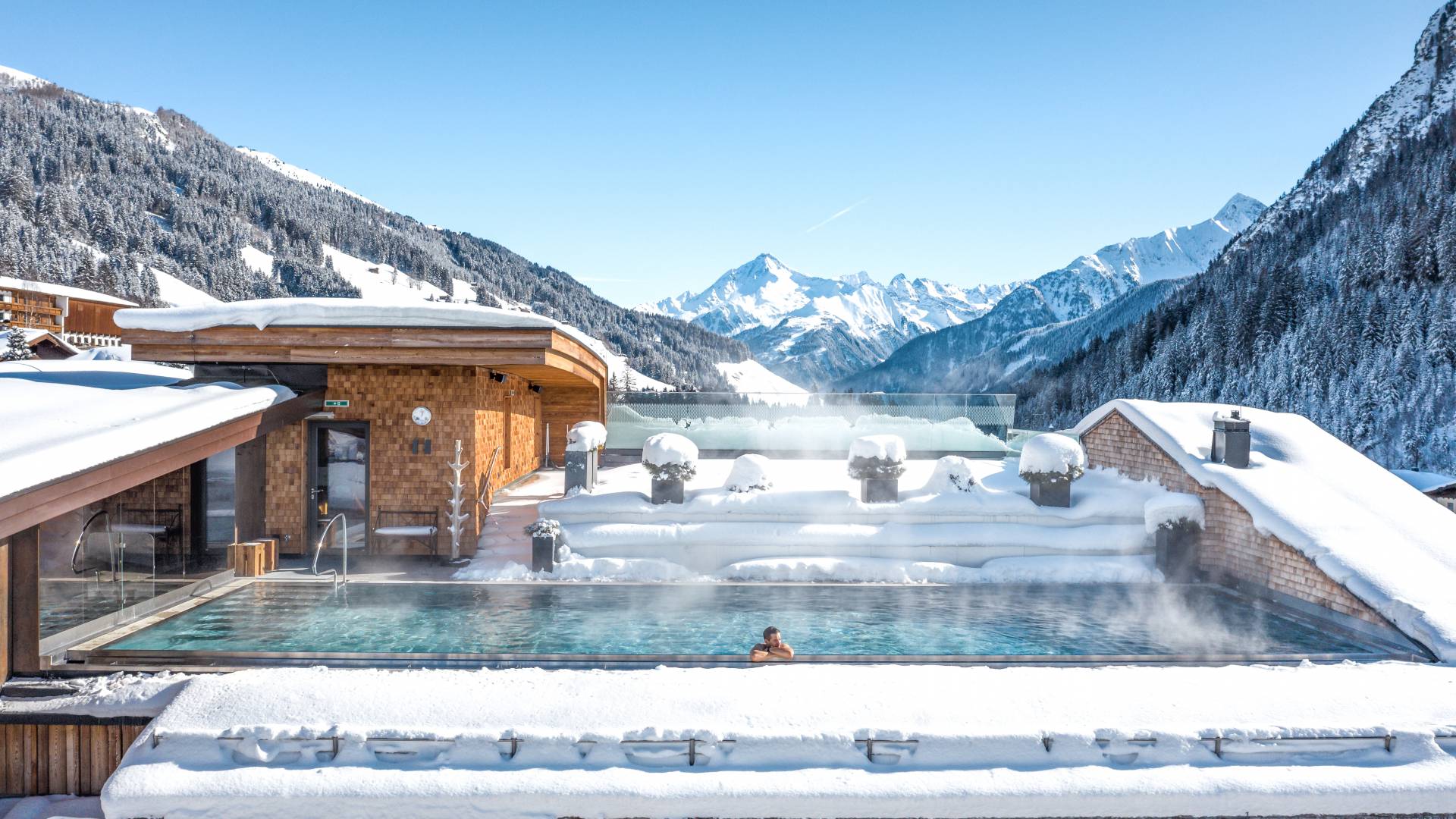 Man in skypool with mountain view in winter