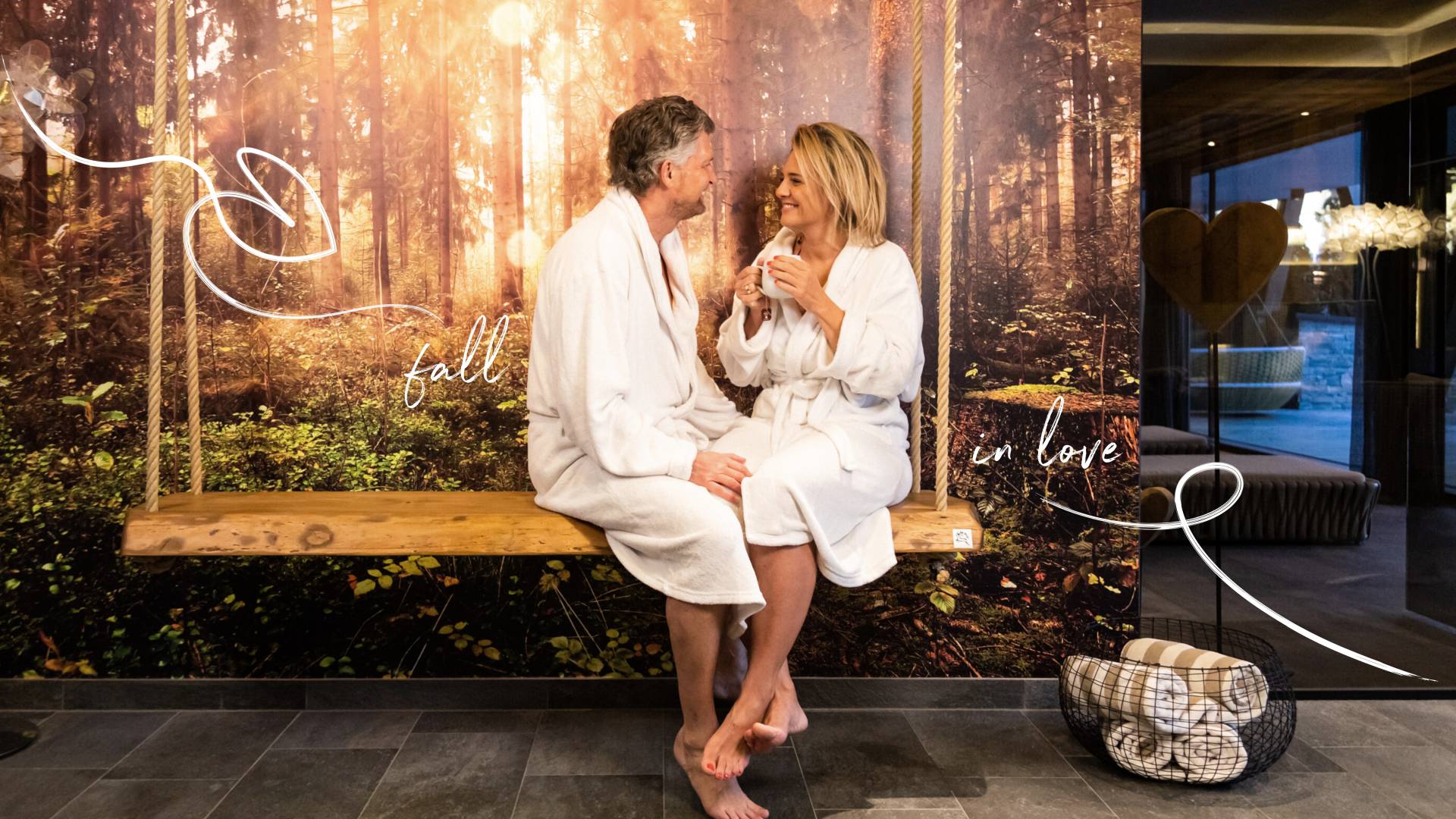 Couple in love in bathrobes sitting on a bench and smiling at each other