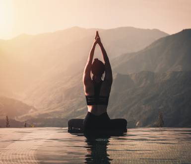 Woman doing yoga pose by the pool