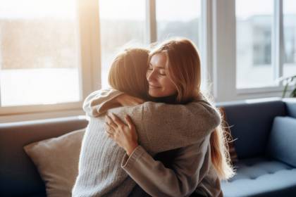 Two girlfriends embrace warmly