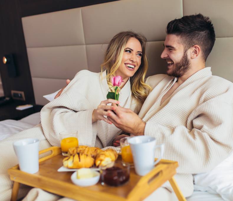 Man and woman with breakfast in bed