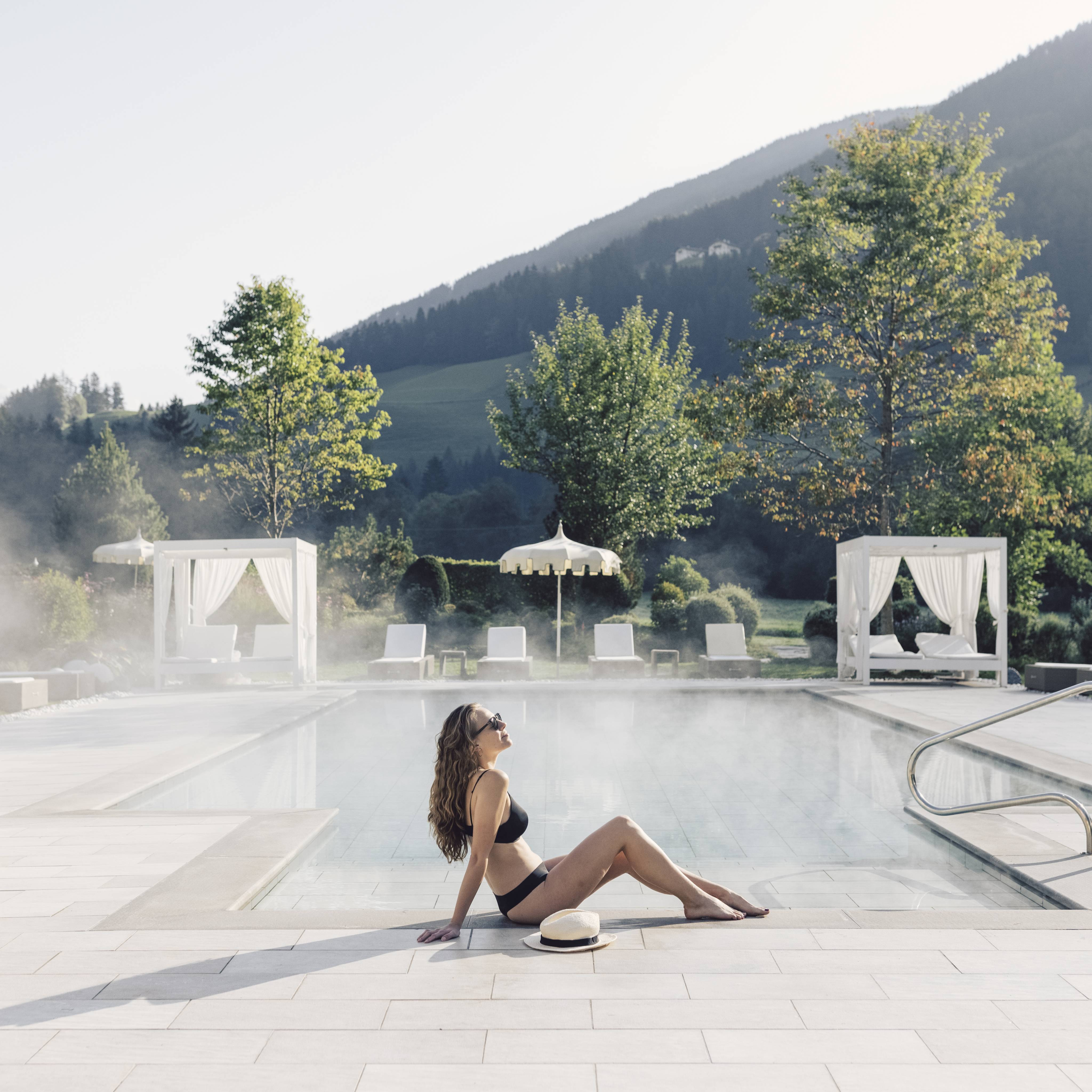 Frau liegt am Pool